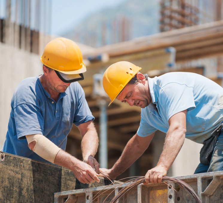 Construction workers working on cement formwork frames